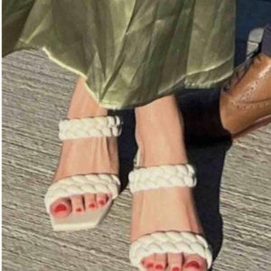 Chunky braided straps add an eye-catching touch to this slide sandal lifted by a